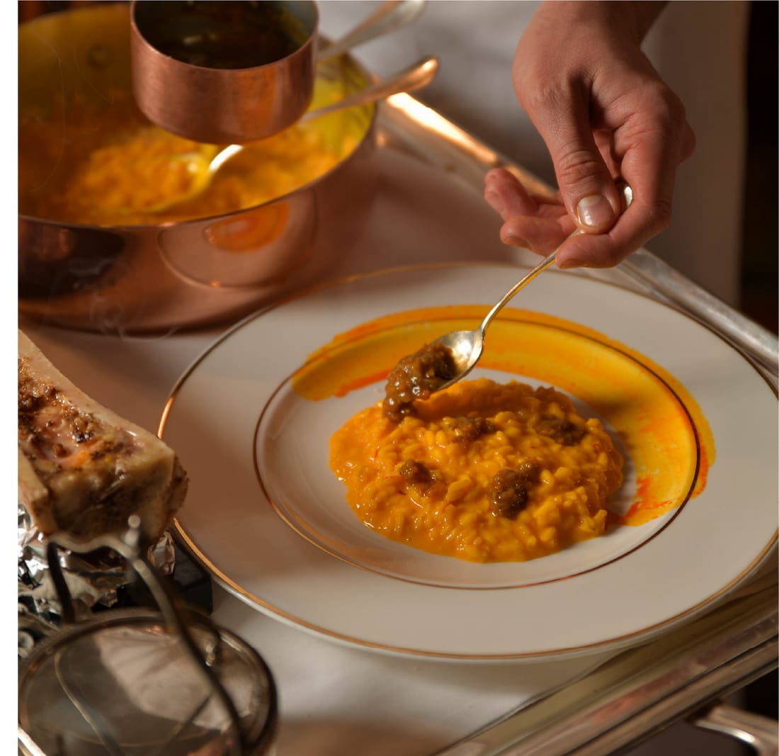 Risotto alla zucca servito al tavolo dalla casseruola di rame