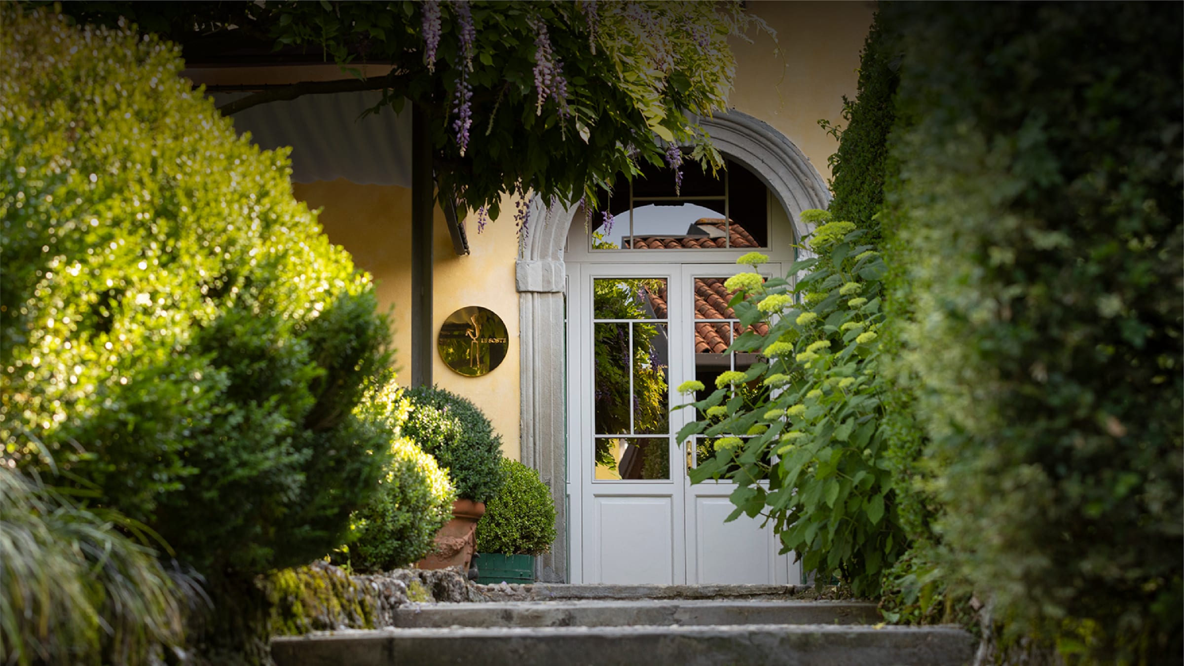 L'ingresso dell'Osteria della Brughiera, tra glicini e ortensie